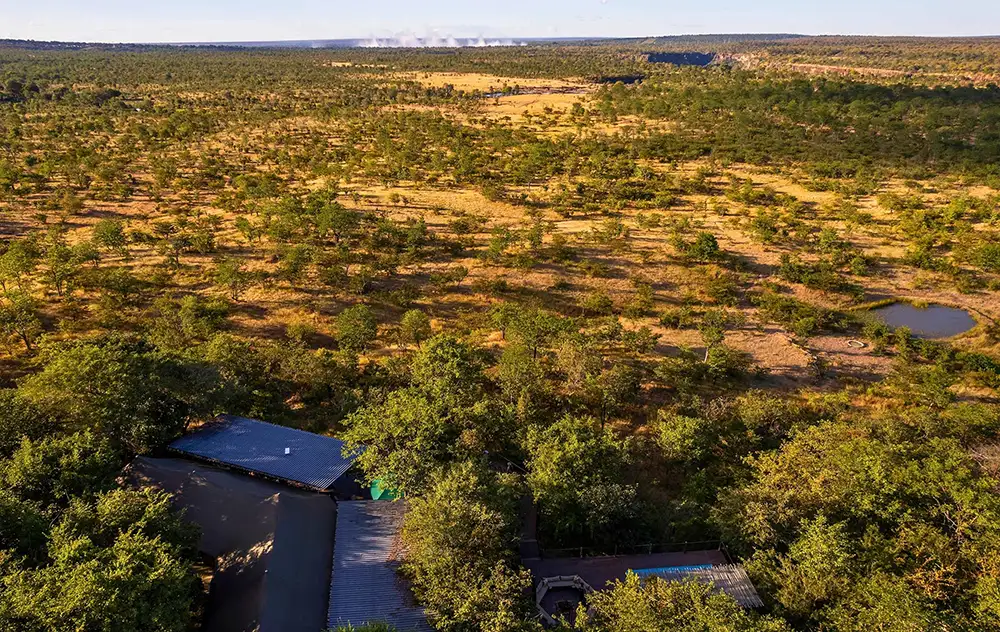 Wide establishing shot of TEC main area or deck — gorge and spray plume on the horizon, warm late-afternoon light. No people required.