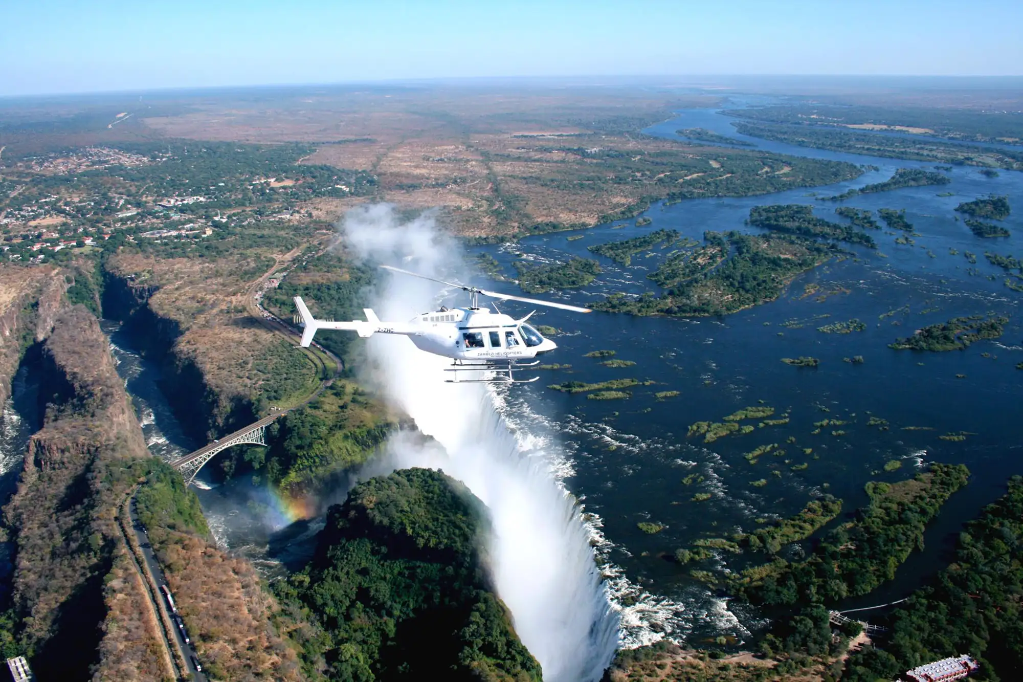 A helicopter on a Victoria Falls helicopter flight banking over the Falls and the Zambezi gorge