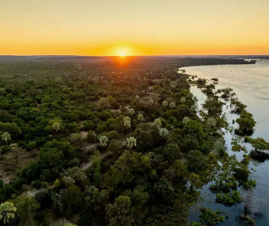 Lush green-season landscape along the Zambezi under dramatic storm clouds